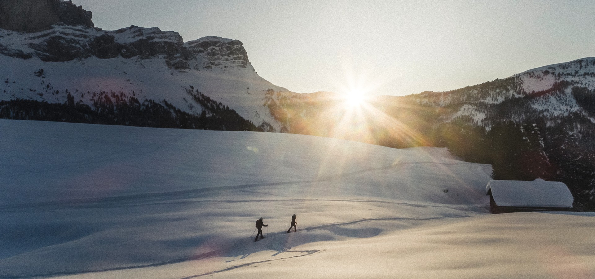 The picture shows two ski tourers in the middle of the snow-covered South Tyrolean Dolomites