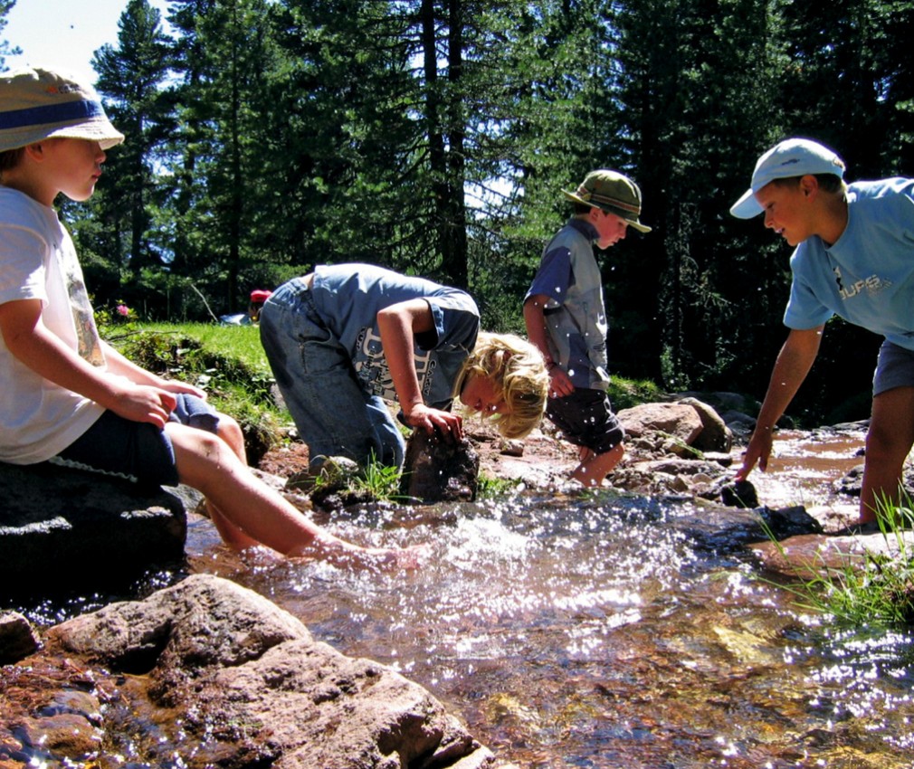 teiser stern Villnöss Eisacktal Südtirol – Urlaub mit Kindern und Familienurlaub im Sommer Das Bild zeigt vier Jungs, welche es genießen am Wasser mitten in der Natur zu spielen.