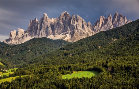 The picture shows the Villnöss Geisler and the green forests and meadows below them.