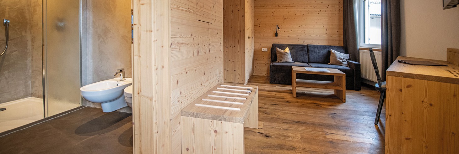 Das Bild zeigt ein liebevoll germachtes kuscheliges Bett im Vollholz-Zimmer des teiser stern.