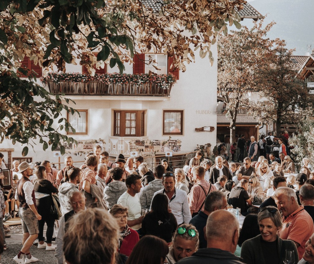 teiser stern Villnöss Eisacktal Südtirol – Veranstaltungen, Aktivitäten, Events Das BIld zeigt ein Foto mit vielen Menschen, welche für ein besonderes Event zusammen kommen. Sie reden miteinander und lachen.