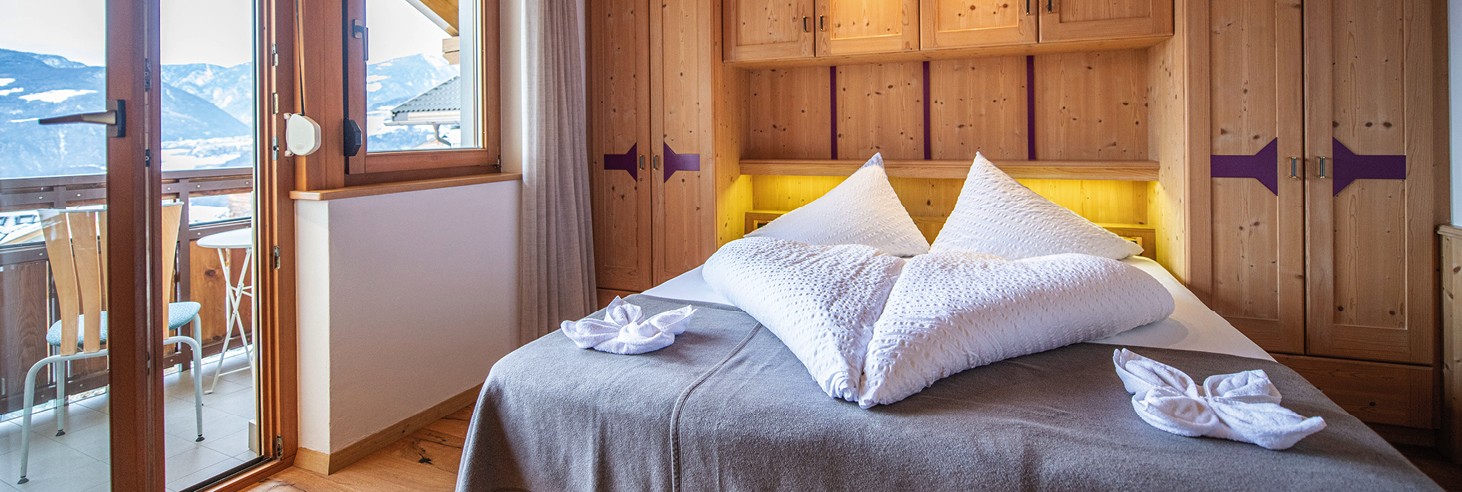 teiser stern Villnöss Eisacktal Südtirol – moderne und hochwertige Zimmer im Südtirolurlaub Das Bild zeigt ein liebevoll germachtes kuscheliges Bett im Vollholz-Zimmer des teiser stern.