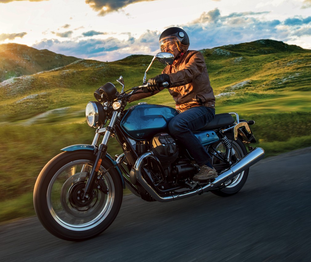 The picture shows a motorcyclist riding down from a mountain pass and enjoying the wind.