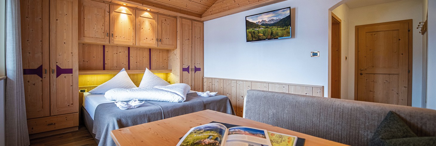 teiser stern Villnöss Eisacktal Südtirol – schöne und ruhige Zimmer für Familien und Paare Das Bild zeigt ein liebevoll germachtes kuscheliges Bett im Vollholz-Zimmer des teiser stern.